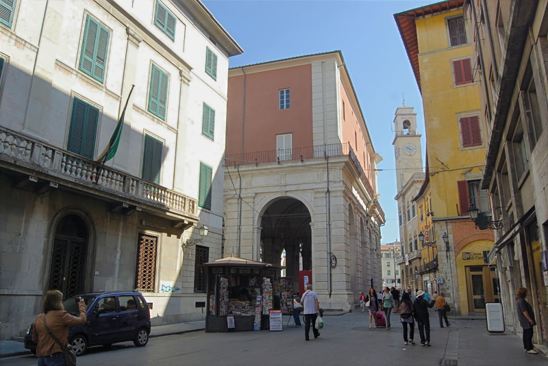 17 - Street view in Pisa, Italy, capturing the historic architecture near the Borgo Stretto area, featuring traditional Italian facades, arcades, and a distant bell tower